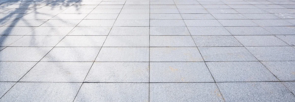 Leerer gepflasterter Bereich mit Rasen